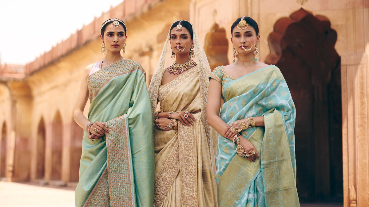 Three brides in pastel Kanjivaram silk sarees under Mughal arches, The Silk Hour by The Saffron House
